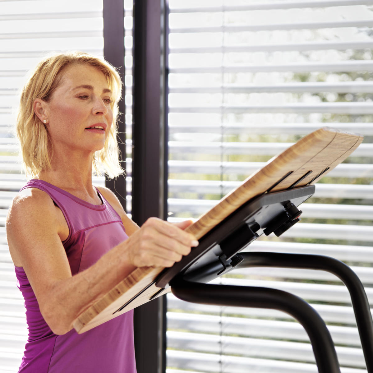 Woman removes table attachment from treadmill desk